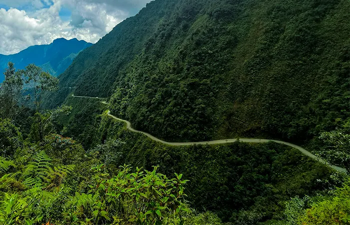 Death Road mountain biking on a narrow winding road through mountain rainforest