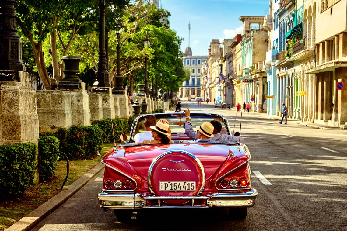 Coche clásico rojo circulando por una calle del centro histórico de La Habana